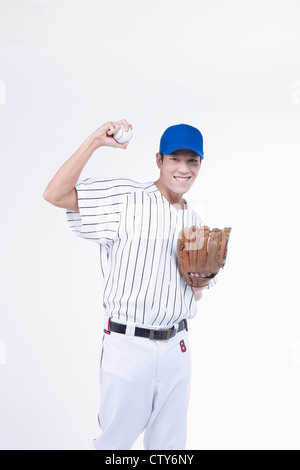 A baseball player holding up a ball Stock Photo