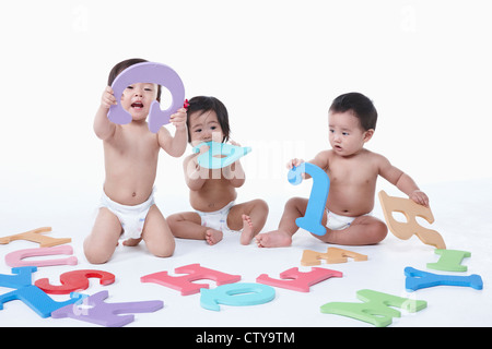 Babies playing with alphabet blocks Stock Photo