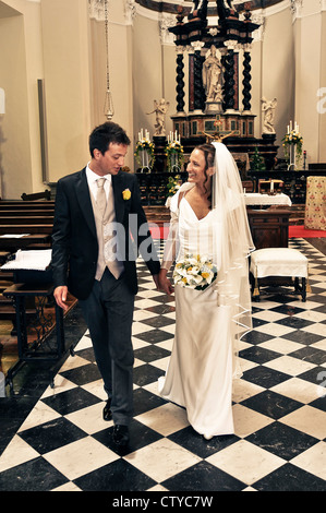 Newlywed Italian couple walking out of church Stock Photo