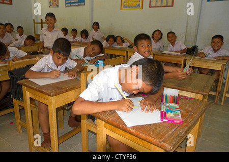 Thai elementary school students sit a desks on the island of Ko Samui, Thailand. Stock Photo