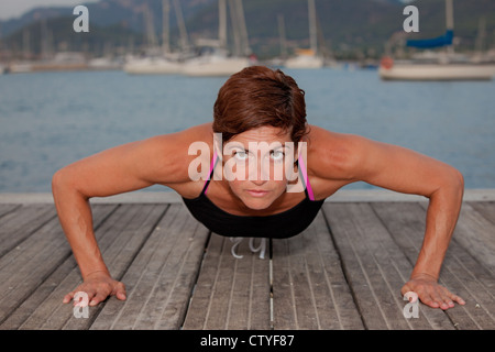 fit healthy middle age woman doing press ups. Stock Photo