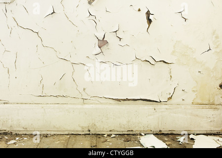 Peeling white paint and skirting board background Stock Photo