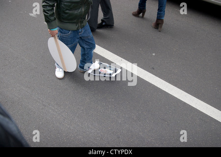 Pro Assad demonstration in Berlin. An Assad loyalist stamps on a picture showing  Yusuf al-Qaradawi. Stock Photo