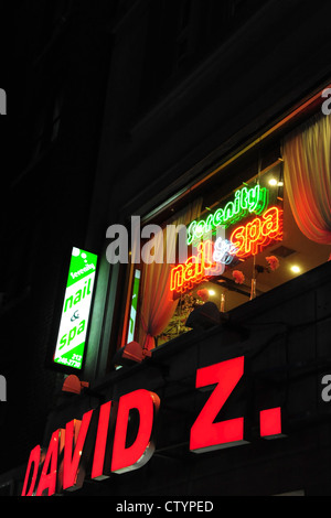 Night portrait red green electric neon signs 'David Z.' shoe shop, 'Serenity Nail & Spa salon window, 846 7th Avenue, New York Stock Photo