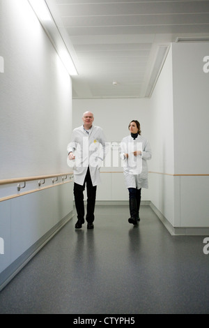 Doctors  walk along hospital corridor Stock Photo