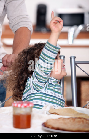 toddler raising arm to ask for permission Stock Photo