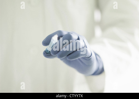 Gloved hand holding syringe Stock Photo