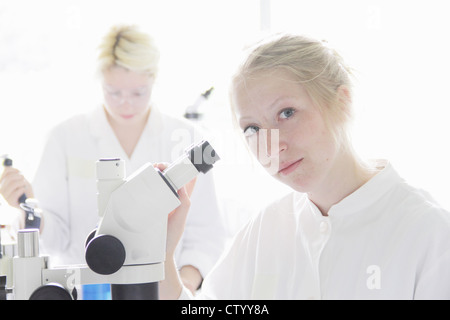 Scientist at microscope in lab Stock Photo