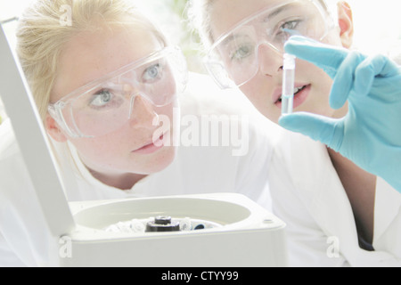 Scientists examining test tube in lab Stock Photo