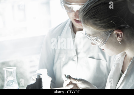 Scientists examining test tube in lab Stock Photo