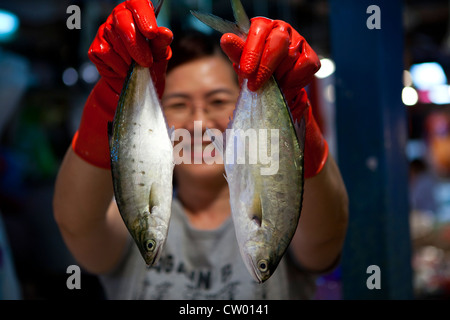 Woman holding up fish in Tai Po Market, New Territories, Hong Kong, China Stock Photo