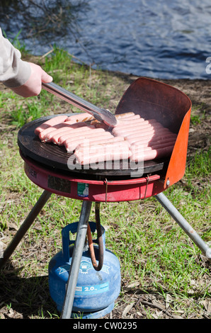 Cooking sausages on a BBQ in the outdoors, Perth, Australia Stock Photo