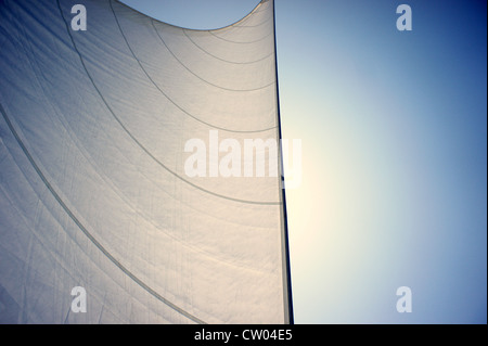 Detail of  flared sails of a sailing yacht, making its way under the sun, across the Ionian Sea. Stock Photo