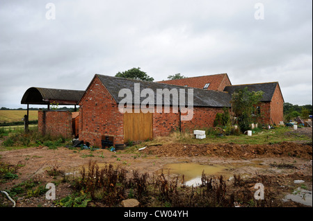 A barn conversion with an old tractor from the original farm in progress Warwicksire, UK Stock Photo