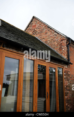 Detail of wooden french doors on a barn conversion in progress Warwicksire, UK Stock Photo