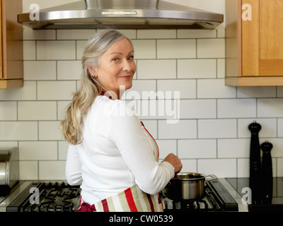 Older woman cooking in kitchen Stock Photo
