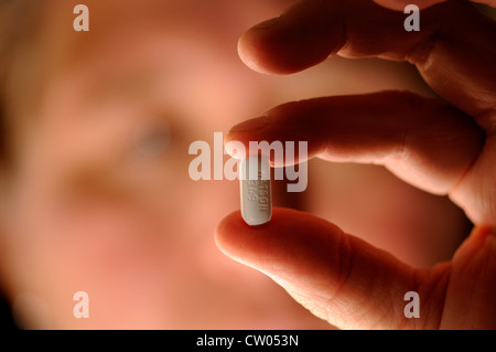 A patient with polycystic kidney disease holds a Vicodin 5/500 m tab, Hydrocodone APAP, a prescribed pain medication. Stock Photo