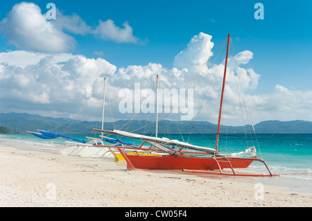 traditional paraw sailing boats on the famous white beach on Boracay island, Philippines Stock Photo