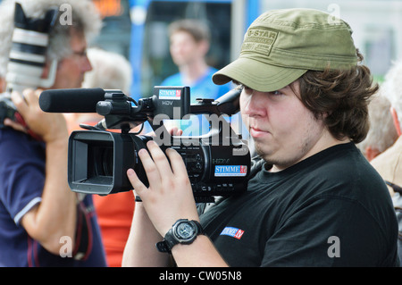 Overweight German cameraman from the regional broadcast station STIMME.TV shooting with semi professional Sony HDV video camera Stock Photo