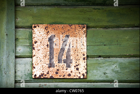 Vintage wooden wall with grunge house number Stock Photo