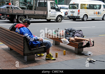 Three  drunk young men with their cans of beer after a heavy drinking binge in Queen Street, Auckland, New Zealand Stock Photo