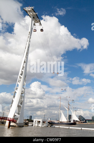 A schooner boat passing under the Emirates Air Line cable car, River Thames at Greenwich, London UK Stock Photo