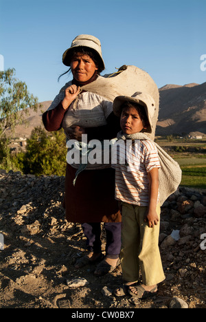 Mother and child carrying bags in the jungle of Peru. Stock Photo