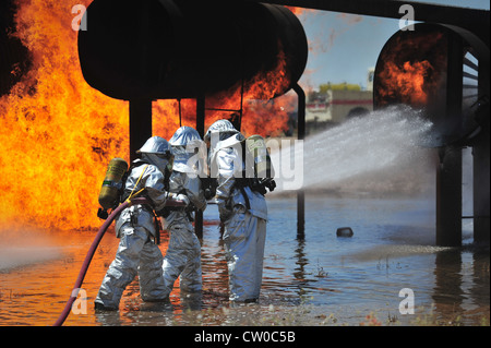 Firefighters with the 27th Special Operations Civil Engineer Squadron work to extinguish an engine fire in the burn pit at Cannon Air Force Base, N.M., Aug. 2, 2012. The pit houses a replicated aircraft equipped with a propane tank and several igniters used to sustain training fires. Stock Photo