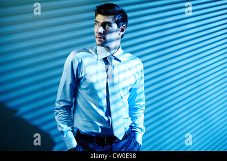 Portrait of elegant businessman looking aside with blind shades on background Stock Photo