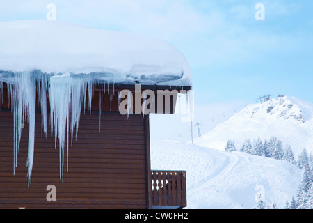 Icicles hanging from cabin in snow Stock Photo