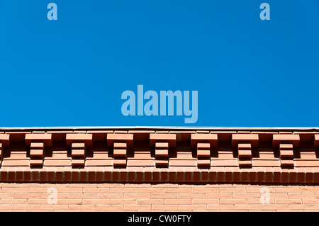 Decorative eaves from a red brick against the blue sky. Stock Photo