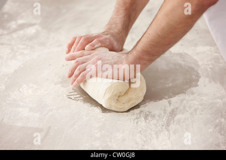 Chef kneading dough in kitchen Stock Photo