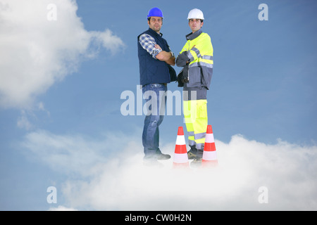 Photo-montage of building workers standing on a cloud Stock Photo