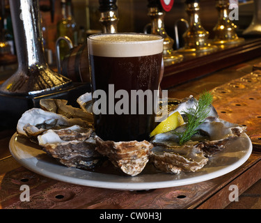 Plate of oysters and stout in bar Stock Photo