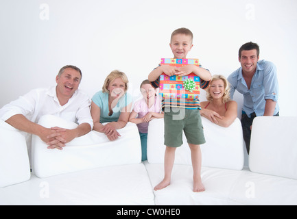 Boy opening gift with family Stock Photo
