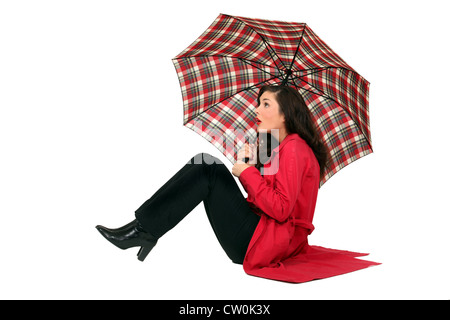 Scottish woman sitting with umbrellas Stock Photo