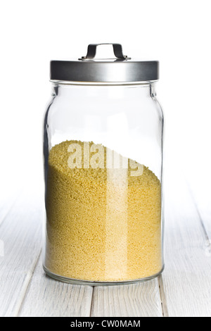 couscous in glass jar on wooden table Stock Photo