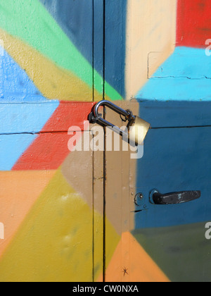 Metal padlock on locked bright colorful door Stock Photo