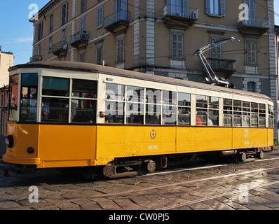 A symbol of the city, the old and traditional orange tram in Milan, Italy Stock Photo