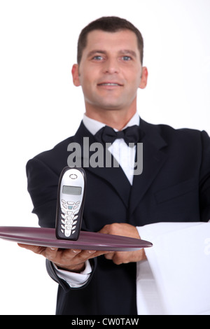 Waitor giving phone on a plate Stock Photo