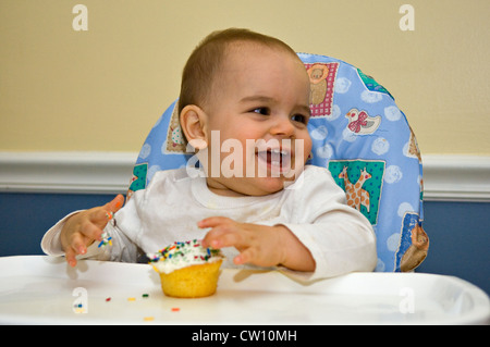 One Year Old Baby Boy Eating Cupcake for the First Time on His Birthday Stock Photo