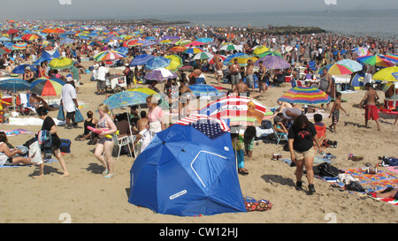 Thousands of people enjoy the beach at Coney Island on the Fourth of July. Stock Photo