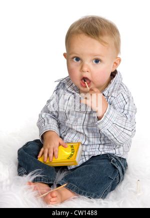 Curious baby playing a dangerous game with matches Stock Photo