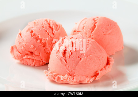 Scoops of strawberry ice cream on plate Stock Photo