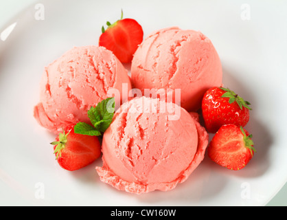 Scoops of strawberry ice cream and fresh strawberries Stock Photo