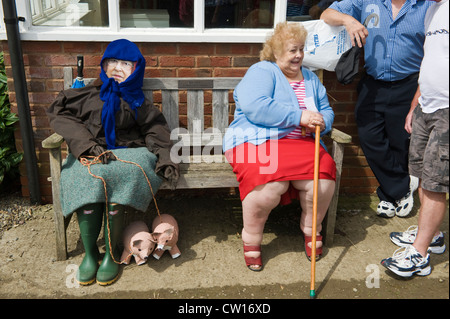 Effigy of The Queen sat on bench with elderly lady during Scarecrow Day in village of Brampton Bryan Herefordshire England UK Stock Photo