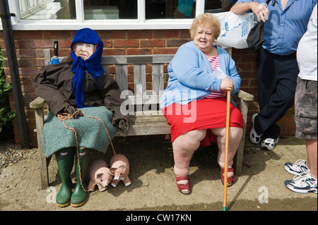 Effigy of The Queen sat on bench with elderly lady during Scarecrow Day in village of Brampton Bryan Herefordshire England UK Stock Photo