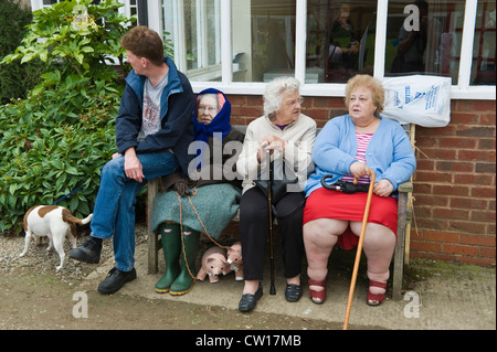Effigy of The Queen sat on bench with two elderly ladies during Scarecrow Day in village of Brampton Bryan Herefordshire England UK Stock Photo