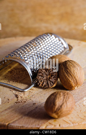 Nutmeg and grater on a wooden background Stock Photo