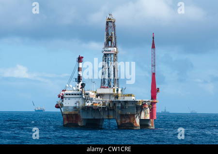 Offshore SS47 oil drilling rig in Campos basin, Rio de Janeiro, Brazil.  Working for Petrobras. Fishing boat floating around. Stock Photo